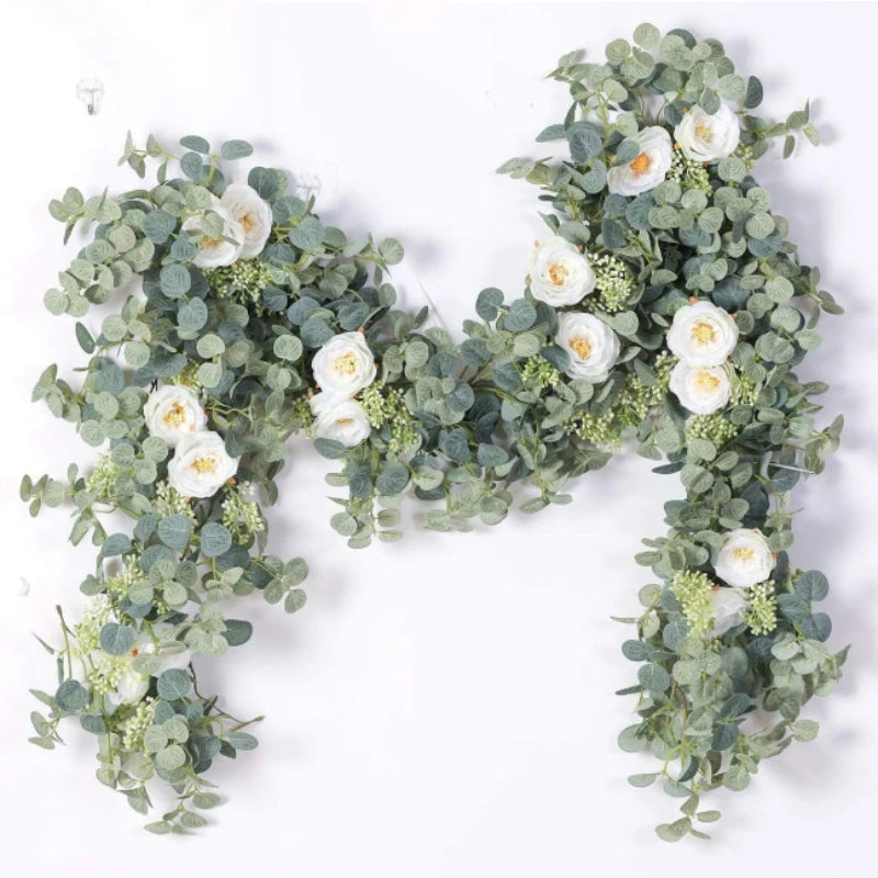 A lush garland of silvery-green eucalyptus leaves and white roses used for floral decoration.
