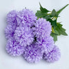 A bouquet of artificial lilac hydrangea flowers and green camellia leaves.