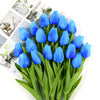 A bouquet of vibrant blue artificial tulips with green stems and leaves.