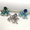 A set of three vintage marine life brooch pins featuring iridescent green, blue, and silver-toned glittery designs.