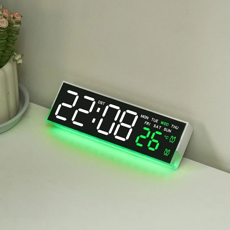 A digital LED alarm clock displaying 22:08 and 26 degrees with a green ambient light on a white surface.