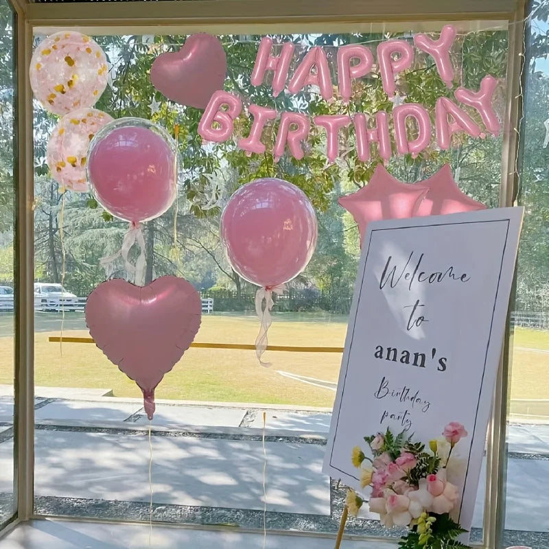A window display featuring pink balloons and a banner that reads Happy Birthday for a party.