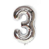 A metallic silver foil balloon shaped like the number three.