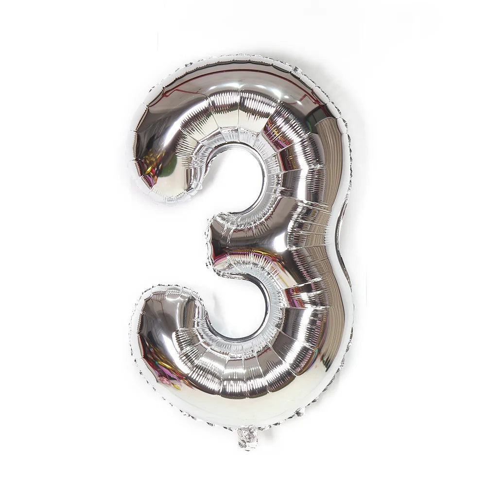 A metallic silver foil balloon shaped like the number three.