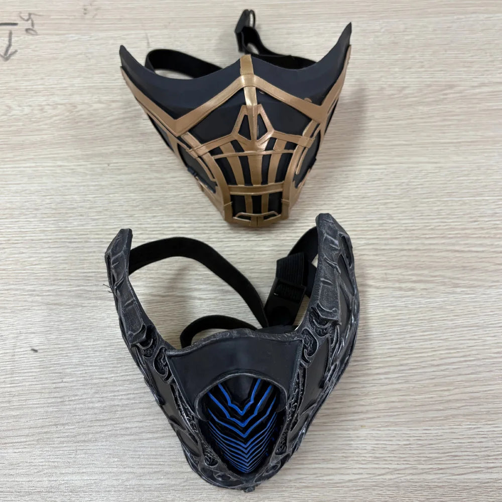 A pair of black and gold half-face masks for Mortal Kombat Sub-Zero and Scorpion cosplay.