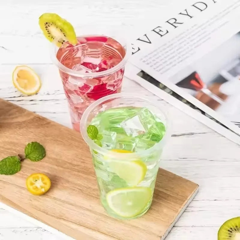 A wooden board displays two glasses of refreshing drinks with ice, lime slices, and mint leaves.