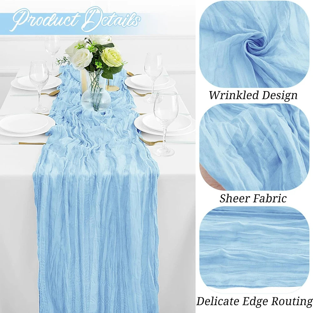 Light blue cheesecloth table runner draped on a white table with floral accents and glassware.
