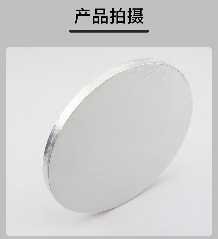 A round, silver cake board is shown in a slight angle against a white background.