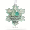 A light blue snowflake-shaped sea glass ornament featuring three white and teal figures.