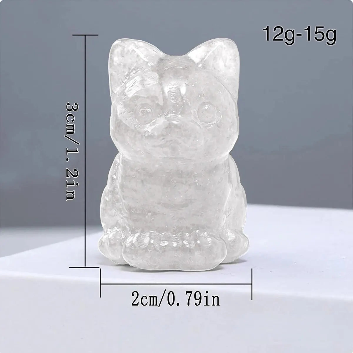 Ornement en cristal sculpté à la main, chat avec des oreilles arrondies et un corps trapu, sur fond blanc.