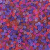 A close-up view of numerous small, round, frosted glass rice beads in various shades of pink, purple, and red.