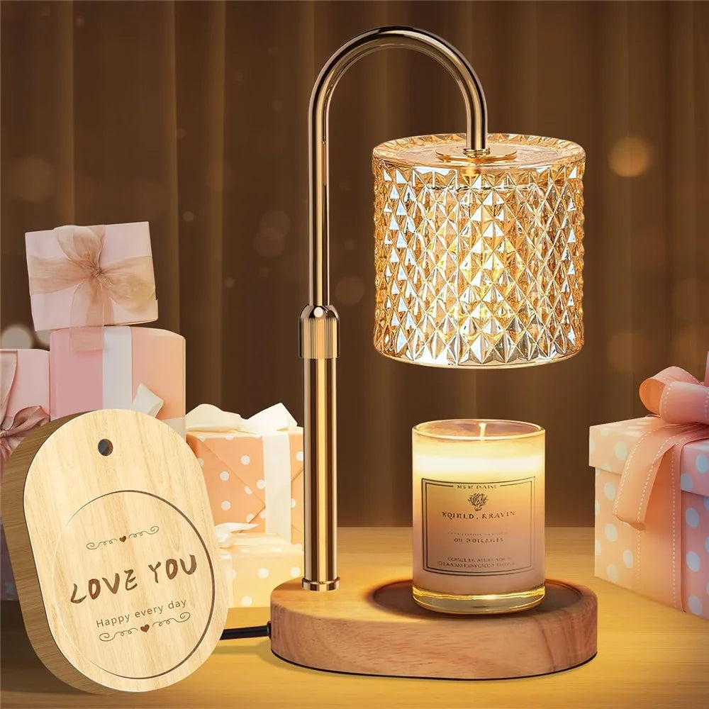 A modern adjustable heat candle warmer lamp with a brass finish sits on a wooden base.