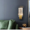 Modern bubble crystal LED wall sconces mounted on a dark gray wall next to a green sofa.