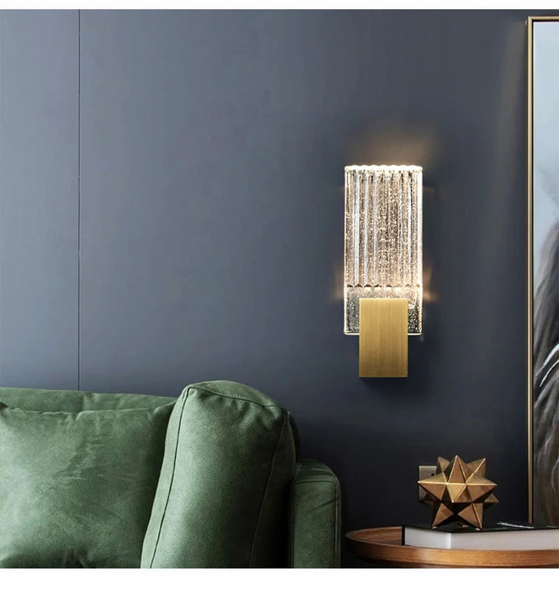 Modern bubble crystal LED wall sconces mounted on a dark gray wall next to a green sofa.