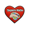 A red heart-shaped charm featuring the text Taquero Mucho and an illustration of a taco.