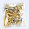 A clear plastic bag filled with pearl-tipped bamboo cocktail picks featuring a silver finish.