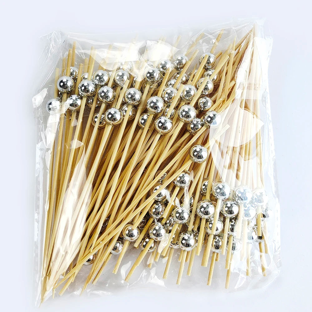A clear plastic bag filled with pearl-tipped bamboo cocktail picks featuring a silver finish.