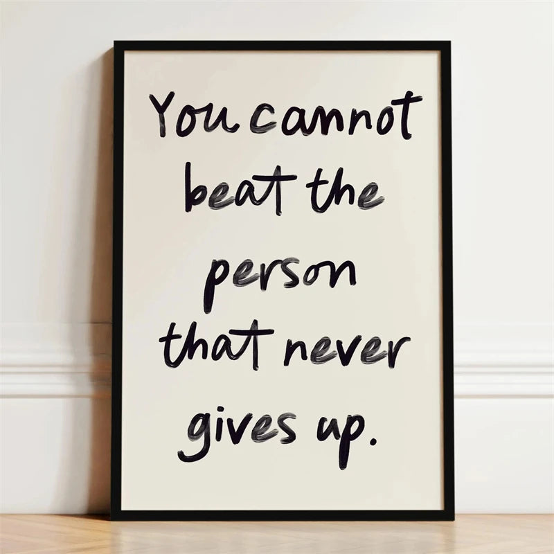 A framed black and white motivational quote print on a light background featuring the text You cannot beat the person that ne