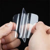 A hand is holding a clear double-sided adhesive tape, showing its transparent and flexible nature.