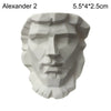 A white plaster bust miniature of a male face in the style of classical Greek mythology.