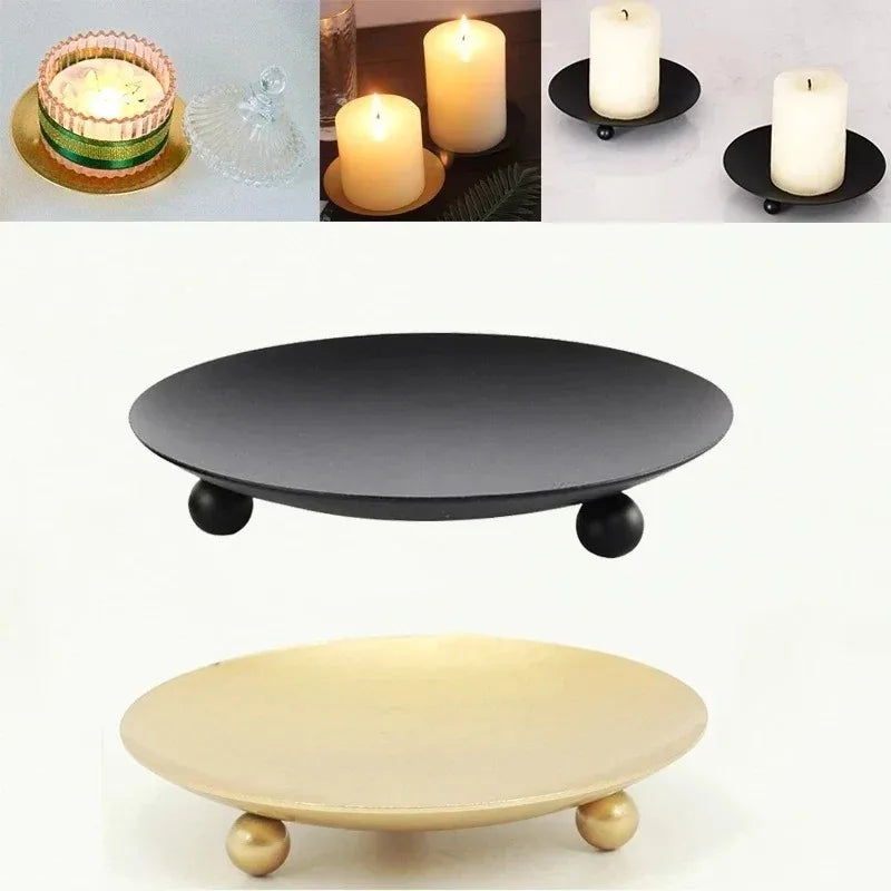 A black iron candle holder tray and a light beige ceramic tray with wooden feet.