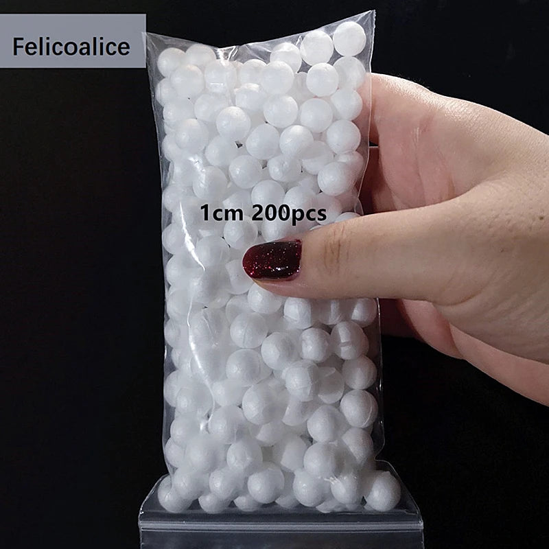 A hand holds a clear plastic bag filled with white polystyrene foam balls for crafting and decorating.