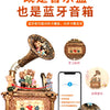 A brass carousel music box decoration with figurines and a modern smartphone displaying music.
