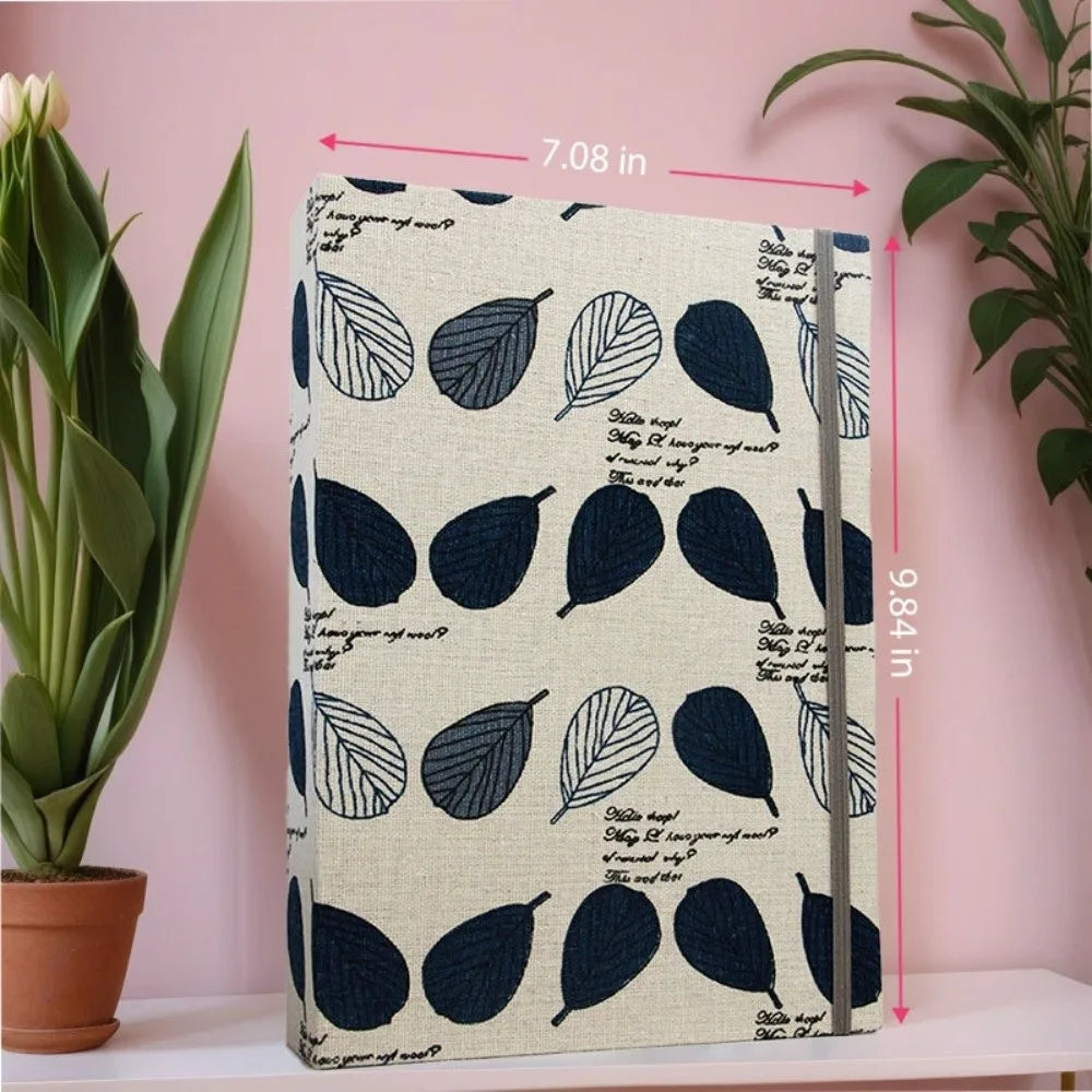 Álbum de scrapbooking de gran capacidad con cubierta azul oscuro y encuadernación plateada, exhibido en una pared rosa.