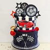 A multi-tiered cake decorated with a red sports car, black and white checkered patterns, and racing wheels.