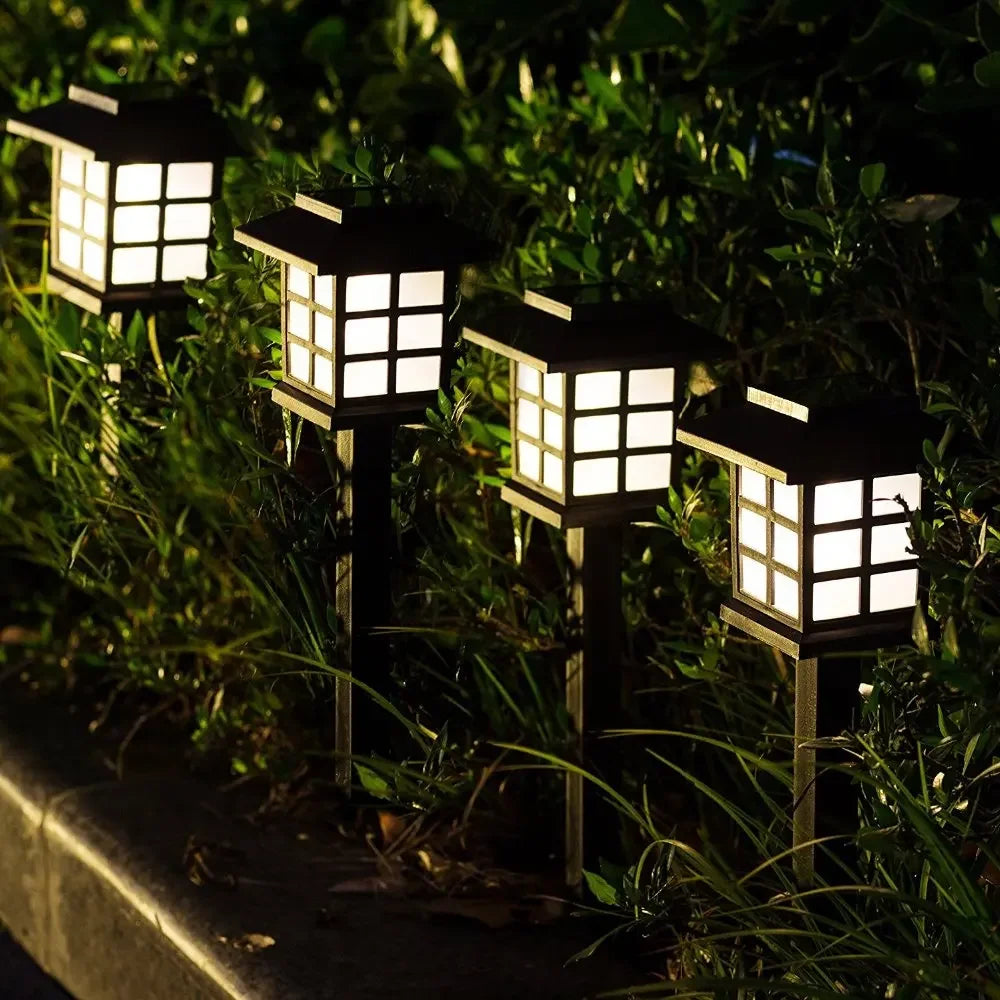 Eight solar powered LED pathway lights illuminating a garden path at night.