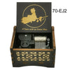 A wooden music box with a black lid featuring a gold silhouette of a woman and a fish, labeled 70-EJ2