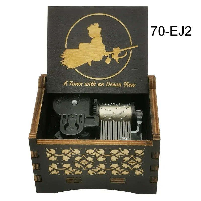 A wooden music box with a black lid featuring a gold silhouette of a woman and a fish, labeled 70-EJ2