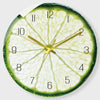 A round clock face made from a sliced lime, showing the numbers and hands.
