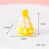 A small yellow and white resin Christmas tree charm with a gold star topper.