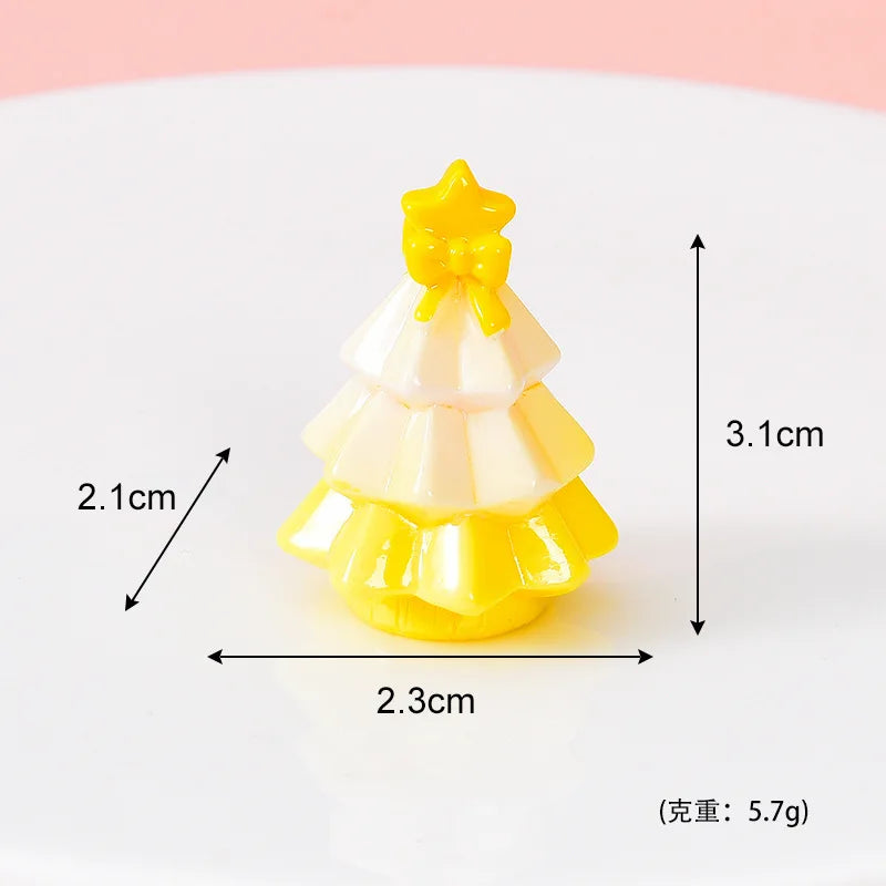 A small yellow and white resin Christmas tree charm with a gold star topper.