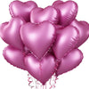 A cluster of pink heart-shaped foil balloons tied together with ribbons.