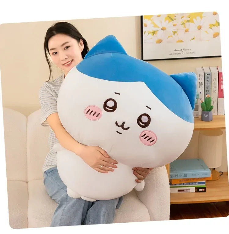 A white and blue Usagi Chiikawa plush doll is being held by a woman in a light gray shirt.