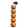 A set of five orange carved pumpkin candles with black faces and teeth.