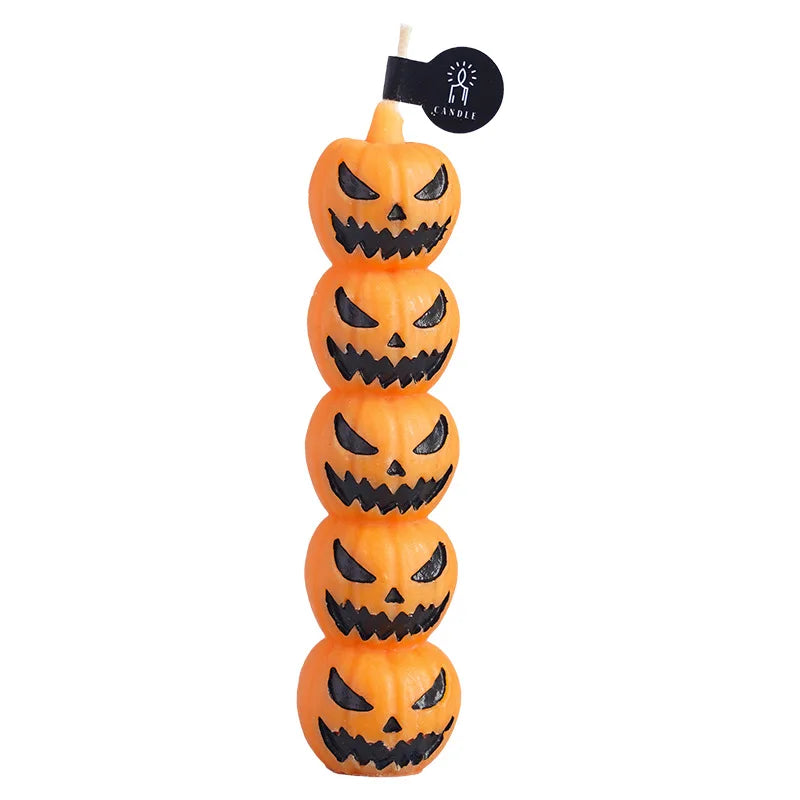 A set of five orange carved pumpkin candles with black faces and teeth.
