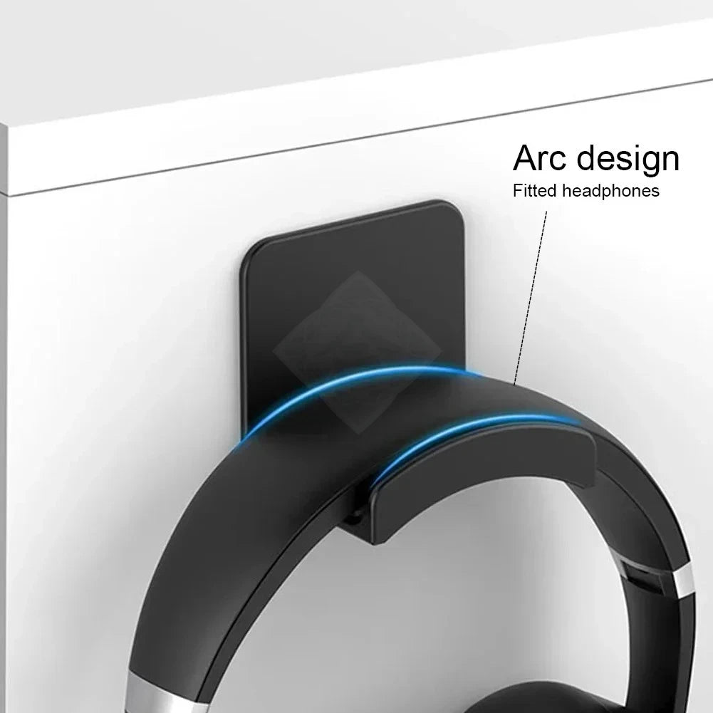 A black arc design headphone stand fitted for use on a desk or wall.