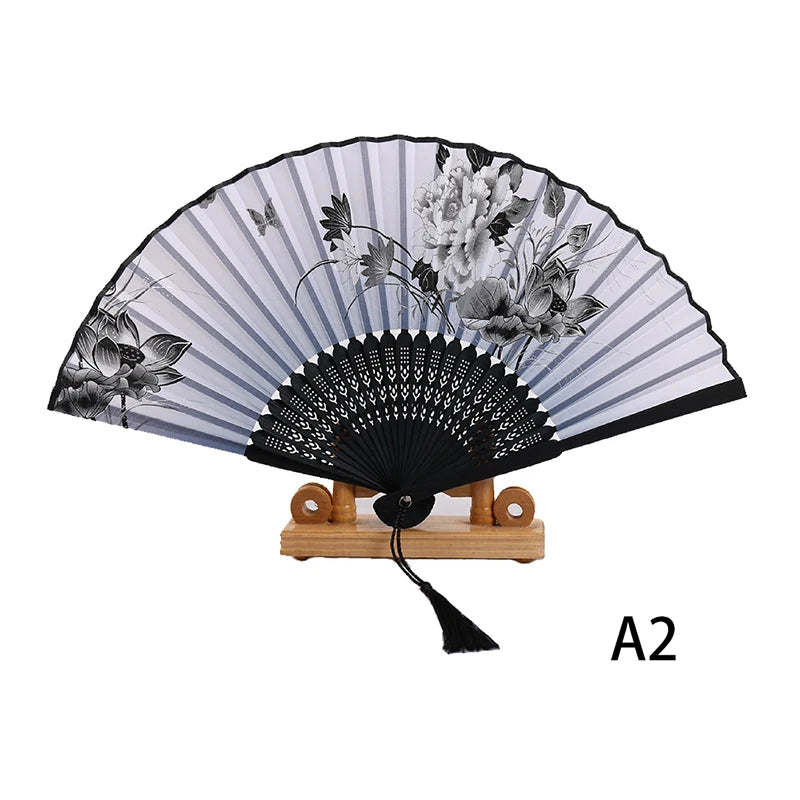 Elegant black and white lace folding hand fan with a wooden stand