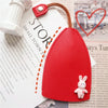 A red cartoon PU leather key holder with a rabbit charm attached, shown against a piece of paper.