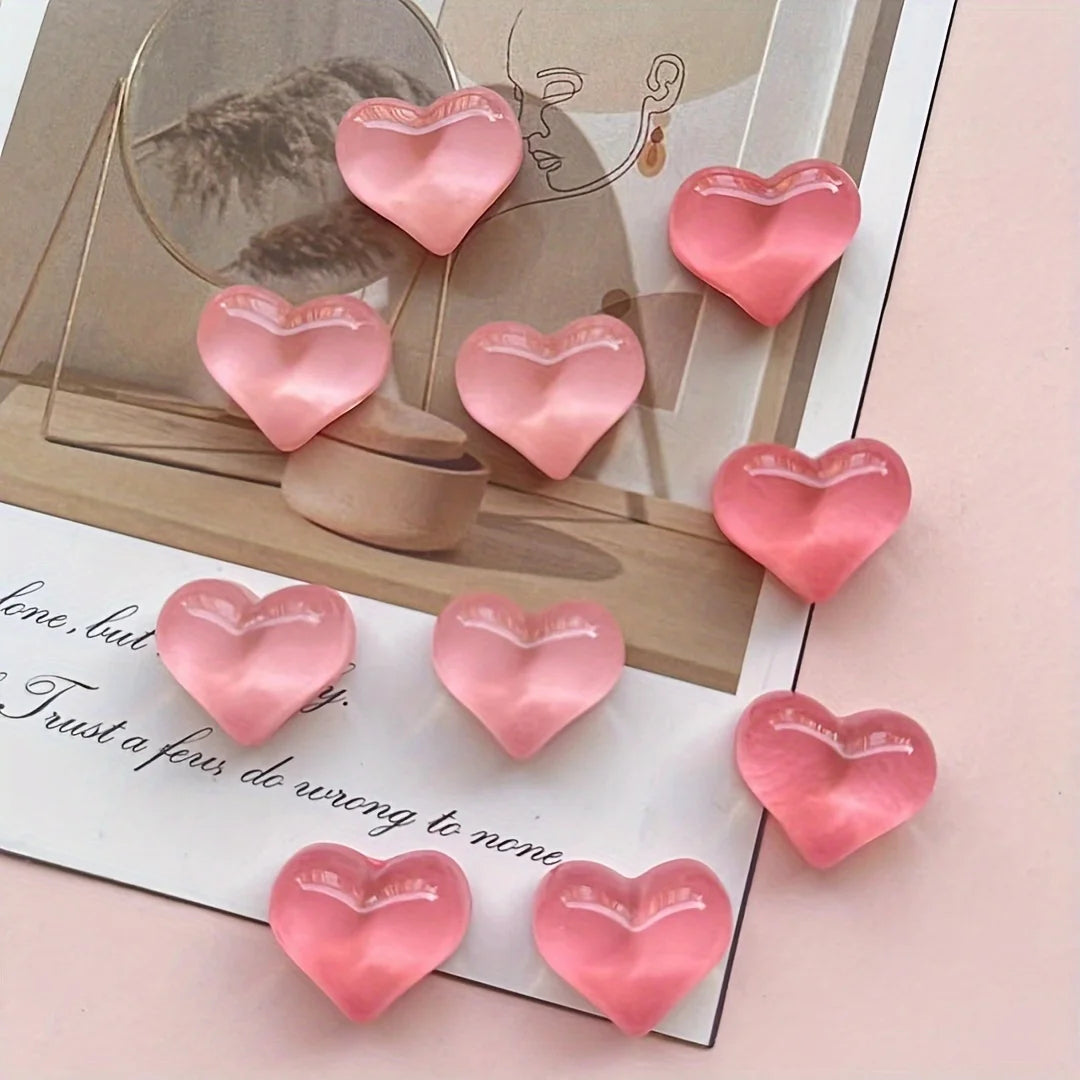 A set of ten heart-shaped pink resin refrigerator magnets arranged on a light background.