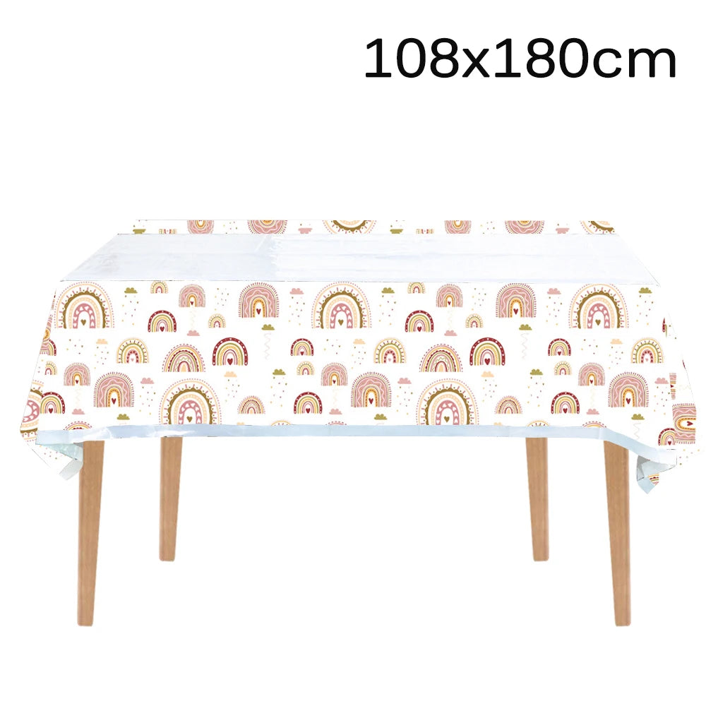 A long white table covered with a colorful rainbow pattern, featuring arched rainbows in pastel colors.