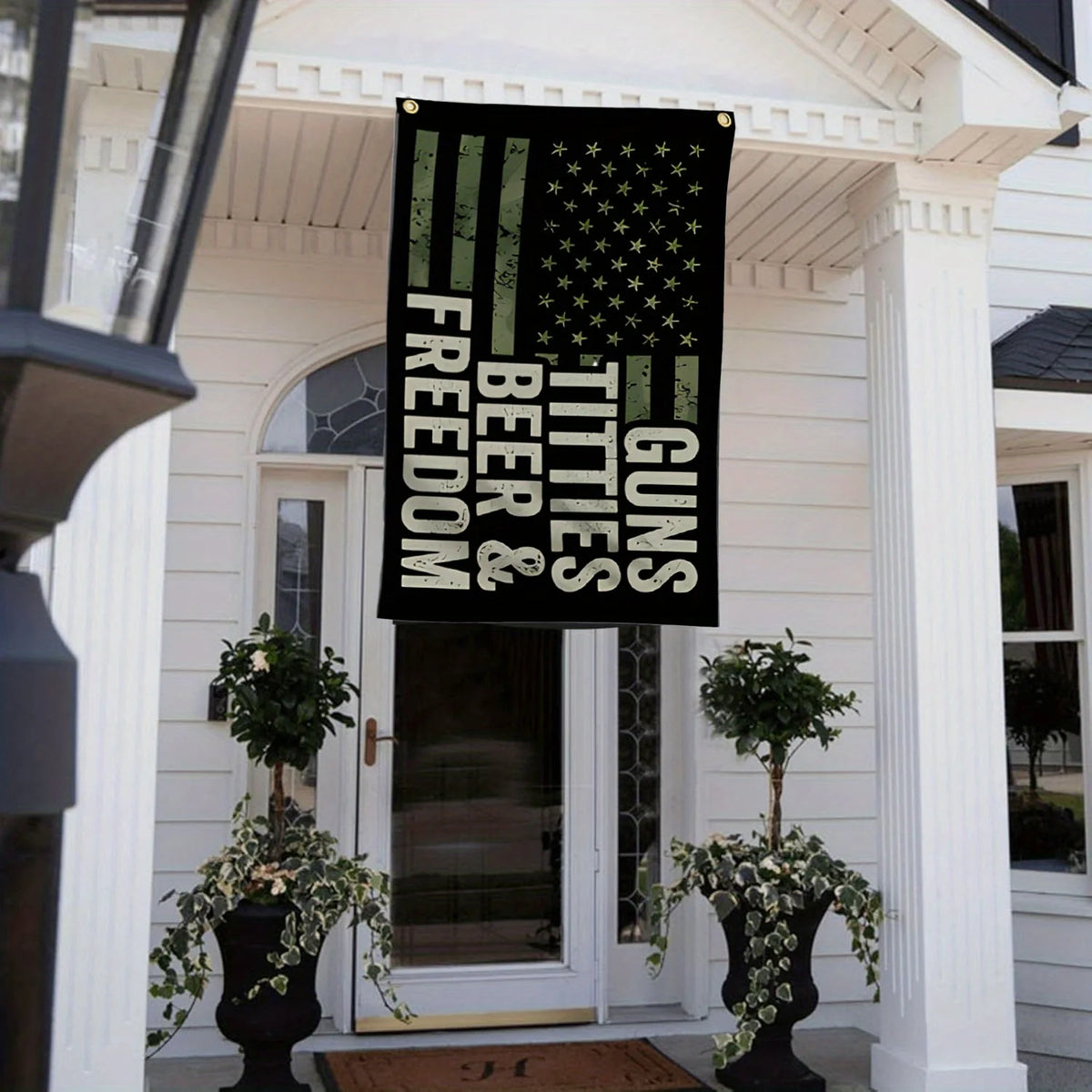 Banner negro con texto verde que dice 'Beer & Freedom Guns and Titties' para un evento en patio exterior