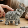A hand holds an elegant silver resin elephant sculpture for home decor.