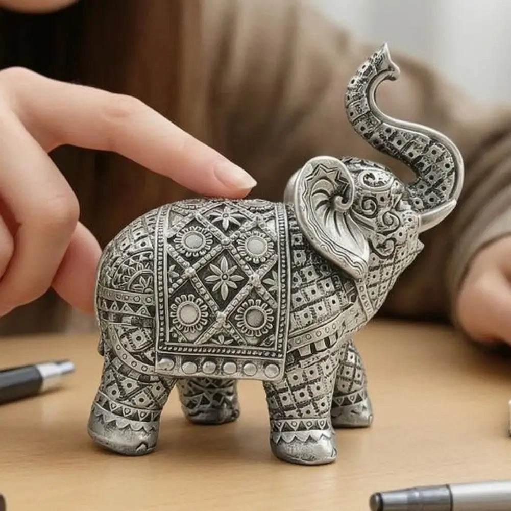 A hand holds an elegant silver resin elephant sculpture for home decor.