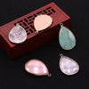 A set of natural agate and rose quartz pendant charms displayed in a wooden box.