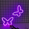 A bright neon pink butterfly sign is displayed against a dark grid background.