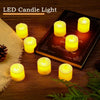 Una colección de luces de velas LED amarillas brillantes dispuestas sobre una superficie de madera junto a una caja oscura.